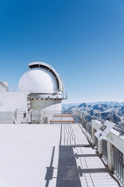 White observatory dome on a rooftop with stunning mountain views in the French Pyrenees.