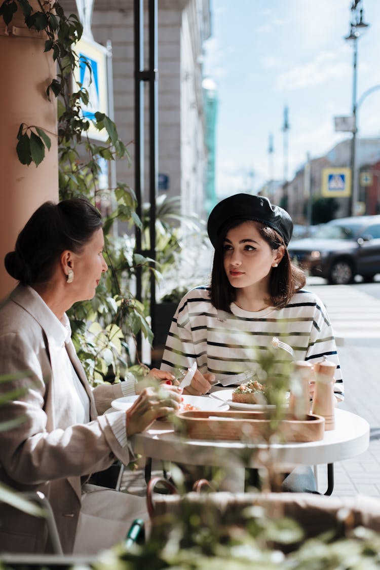 An Elderly Woman Talking To Her Granddaughter While Having Brunch