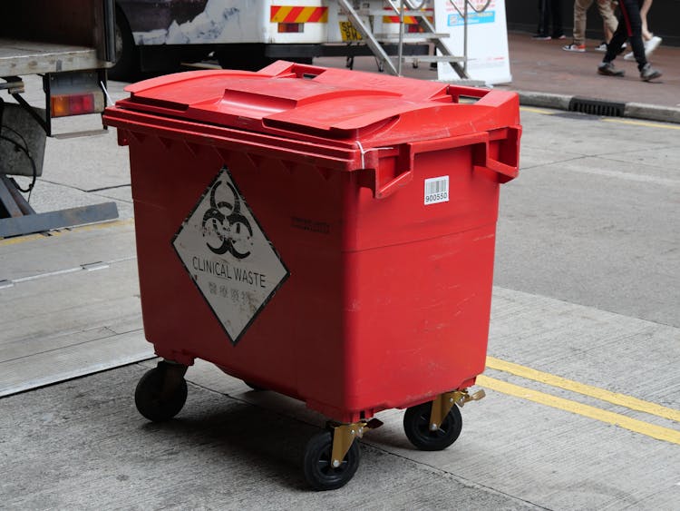 A Red Plastic Garbage Bin For Clinical Waste