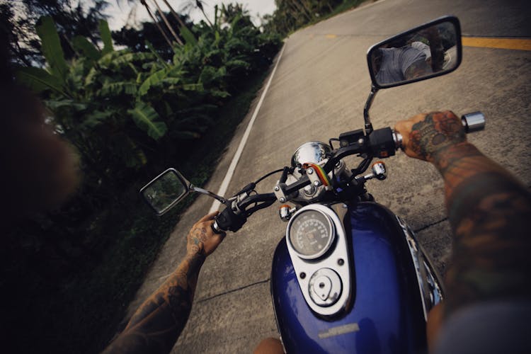 Man Riding A Motorcycle Along An Asphalt Road