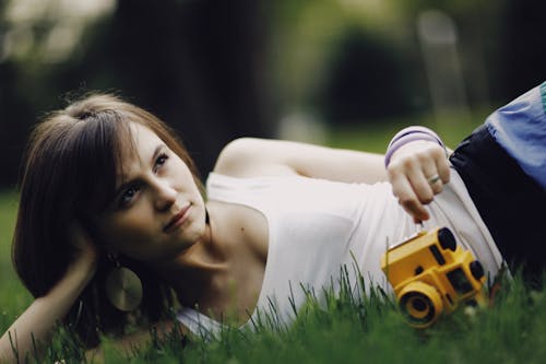 Woman in White Tank Top Holding aYellow Camera