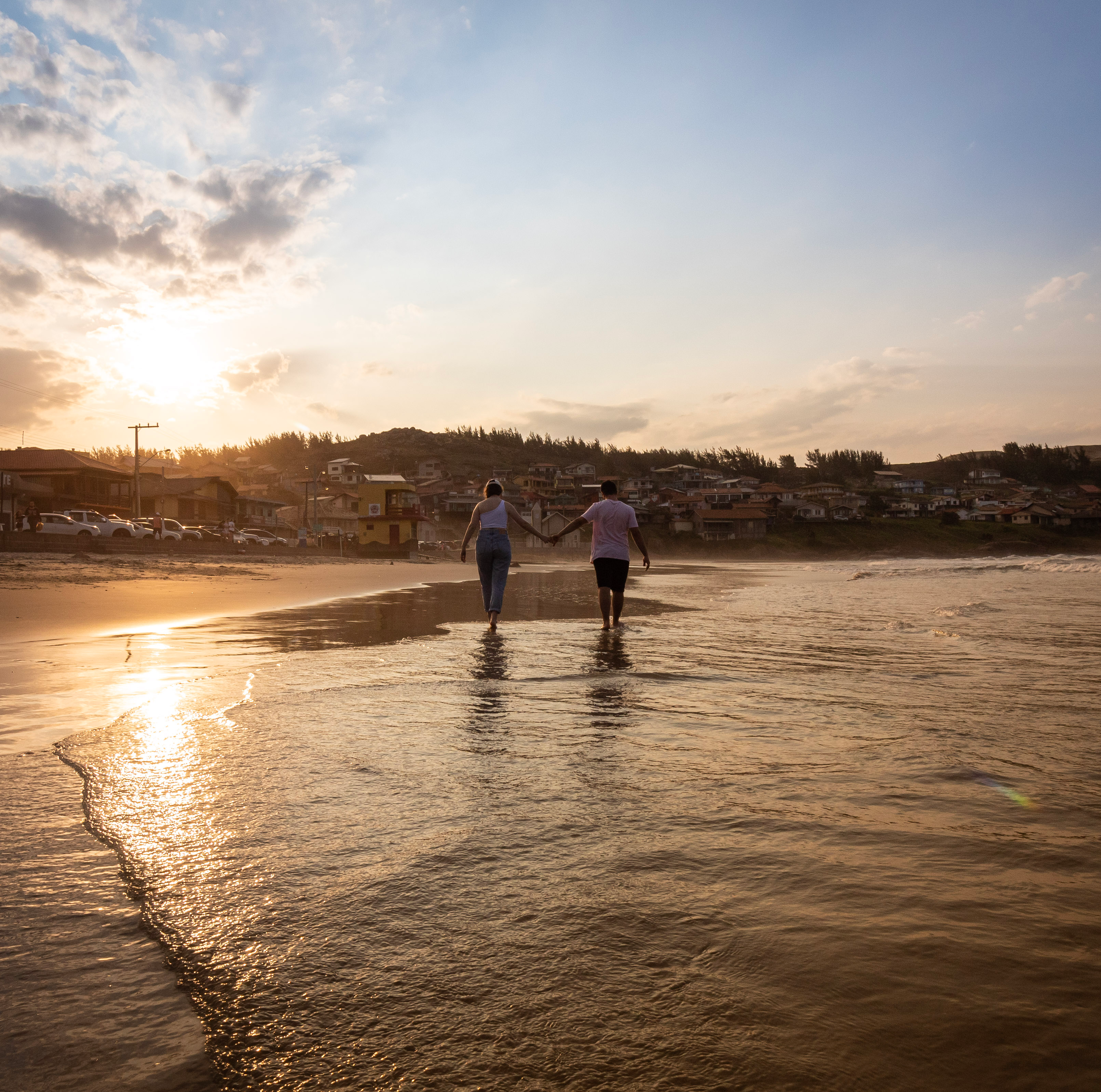 Family walking along a calm beach in Santa Catarina at low tide