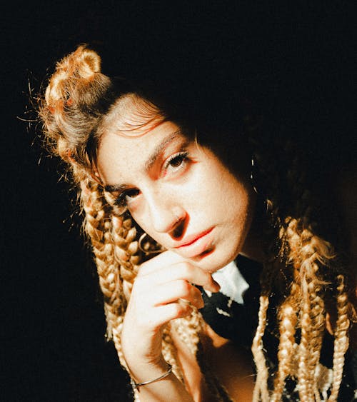 A Woman with Braided Hair with Her Hand on Her Chin