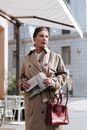 Man in Brown Coat Holding Newspaper