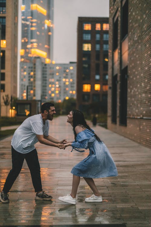 Photo of a Couple Holding Hands on the Street