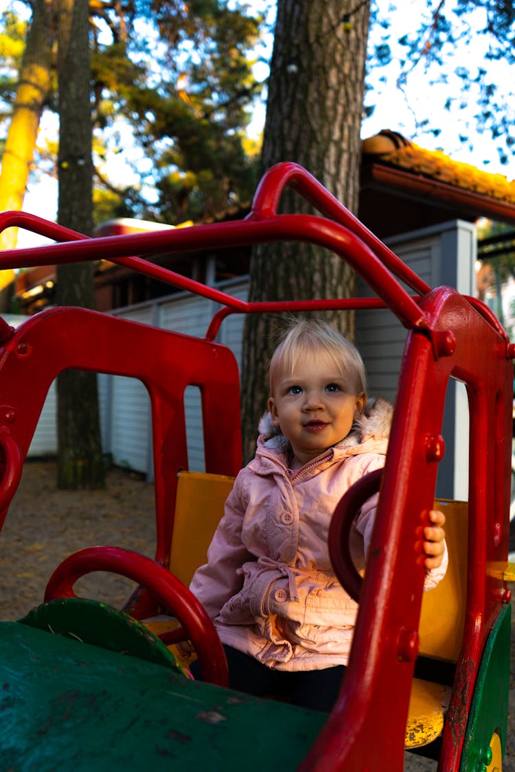 A Baby Girl Sitting On The Playground