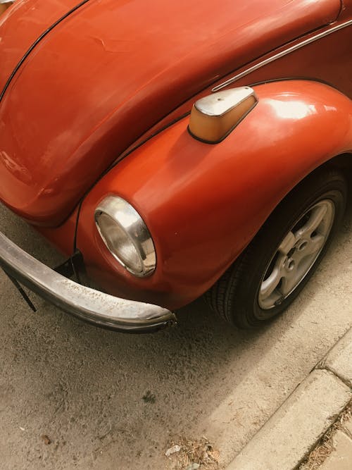 Red Volkswagen Beetle Parked on Concrete Pavement