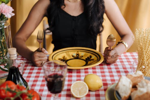 Womans Hands Holding Fork and Spoon by Table