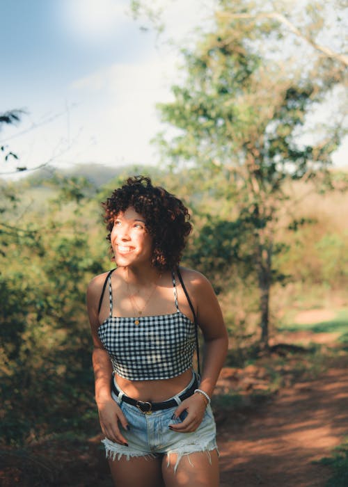 A Woman in Plaid Crop Top Standing in Forest