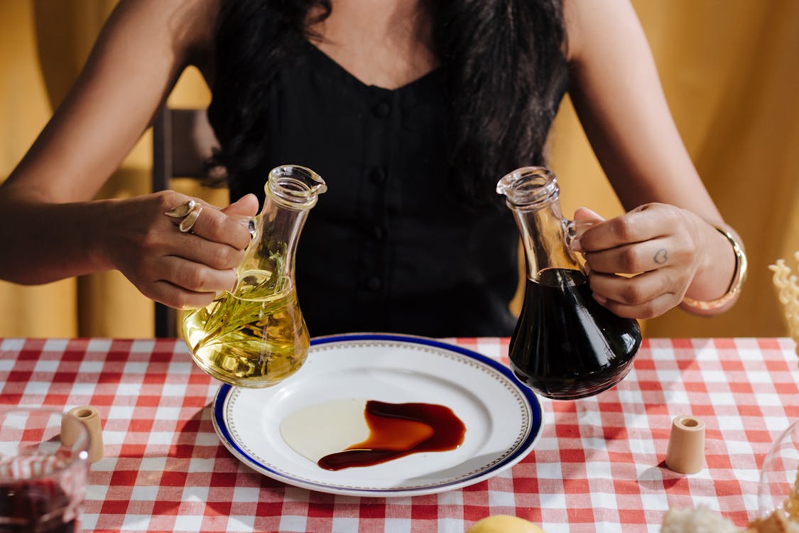 Free Woman with Olive Oil and Vinegar Bottles in Hands Stock Photo