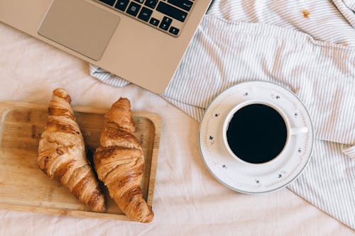 A Light Meal on Bed Beside a Laptop