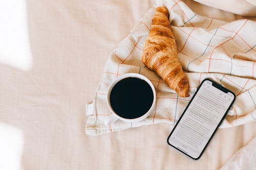Free Croissant Bread and Black Coffee on the Bed Stock Photo