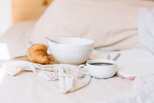 Free Breakfast with Croissant in Bed Stock Photo