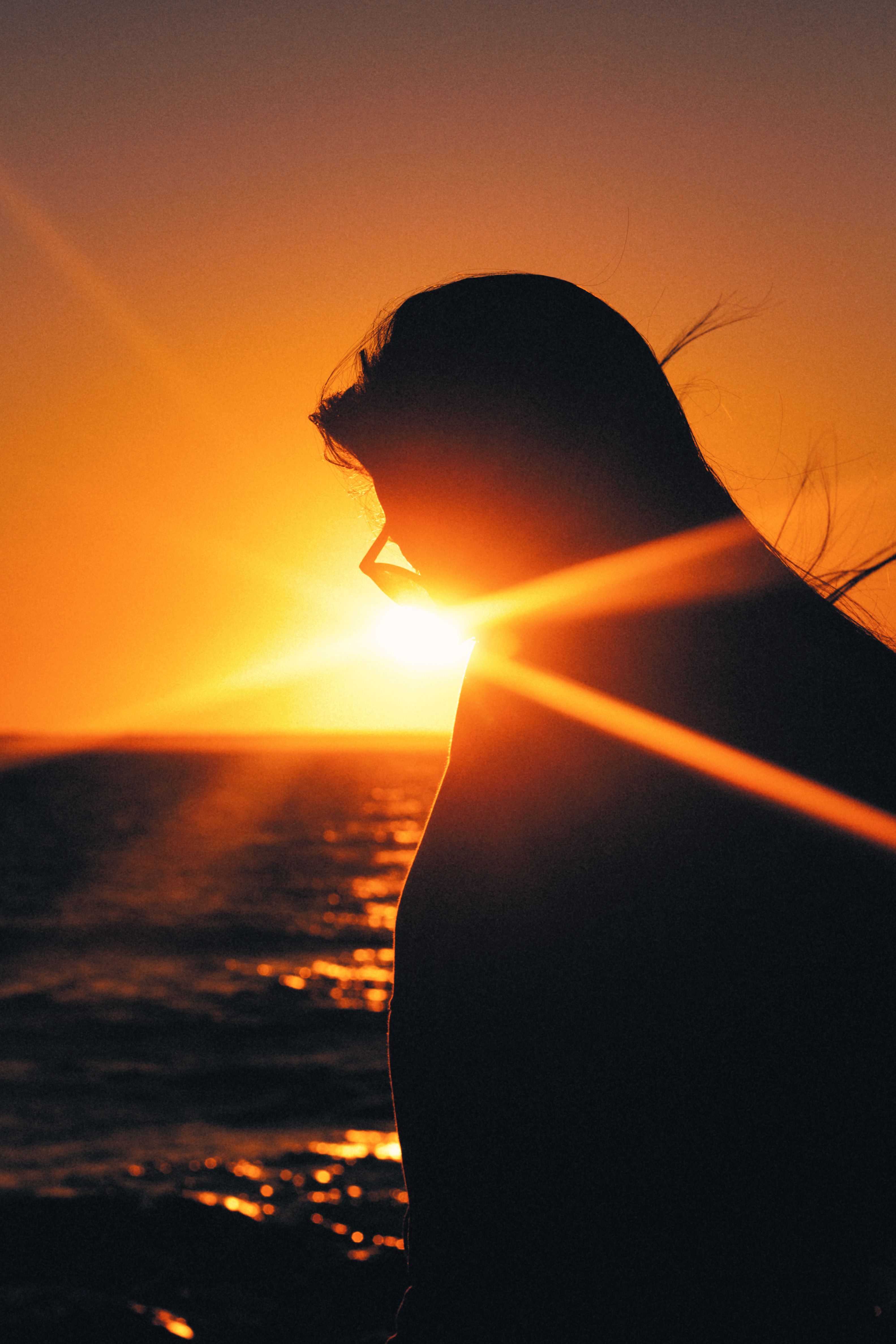 Silhouette of Woman Standing Near Body of Water during Sunset · Free ...