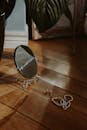 Silver Framed Round Mirror on Brown Wooden Floor