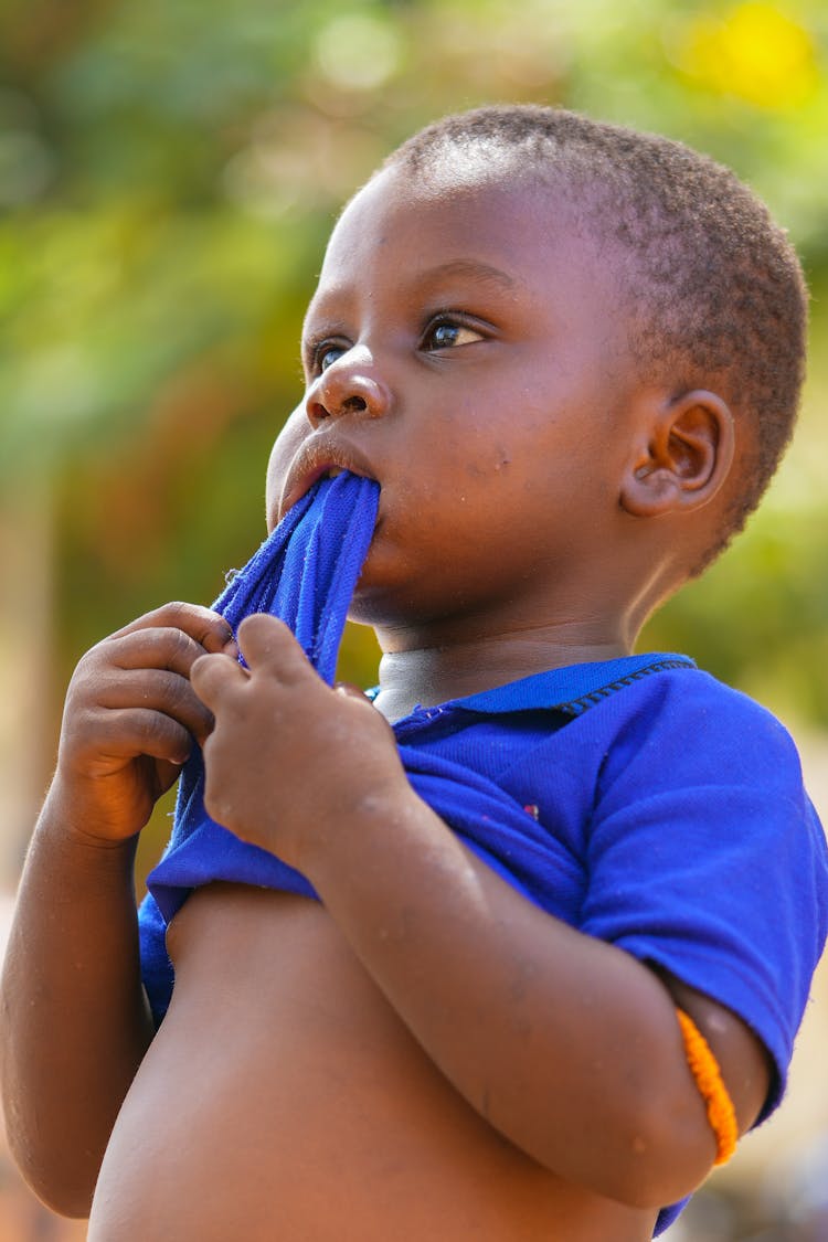 Little Boy Chewing On His Shirt