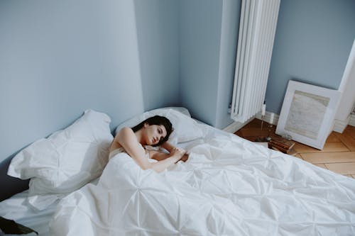 Free A Woman Lying Down on the Bed  Stock Photo