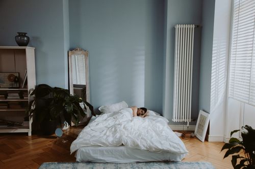 Free Woman sleeping peacefully in a cozy and stylish bedroom with soft natural light. Stock Photo