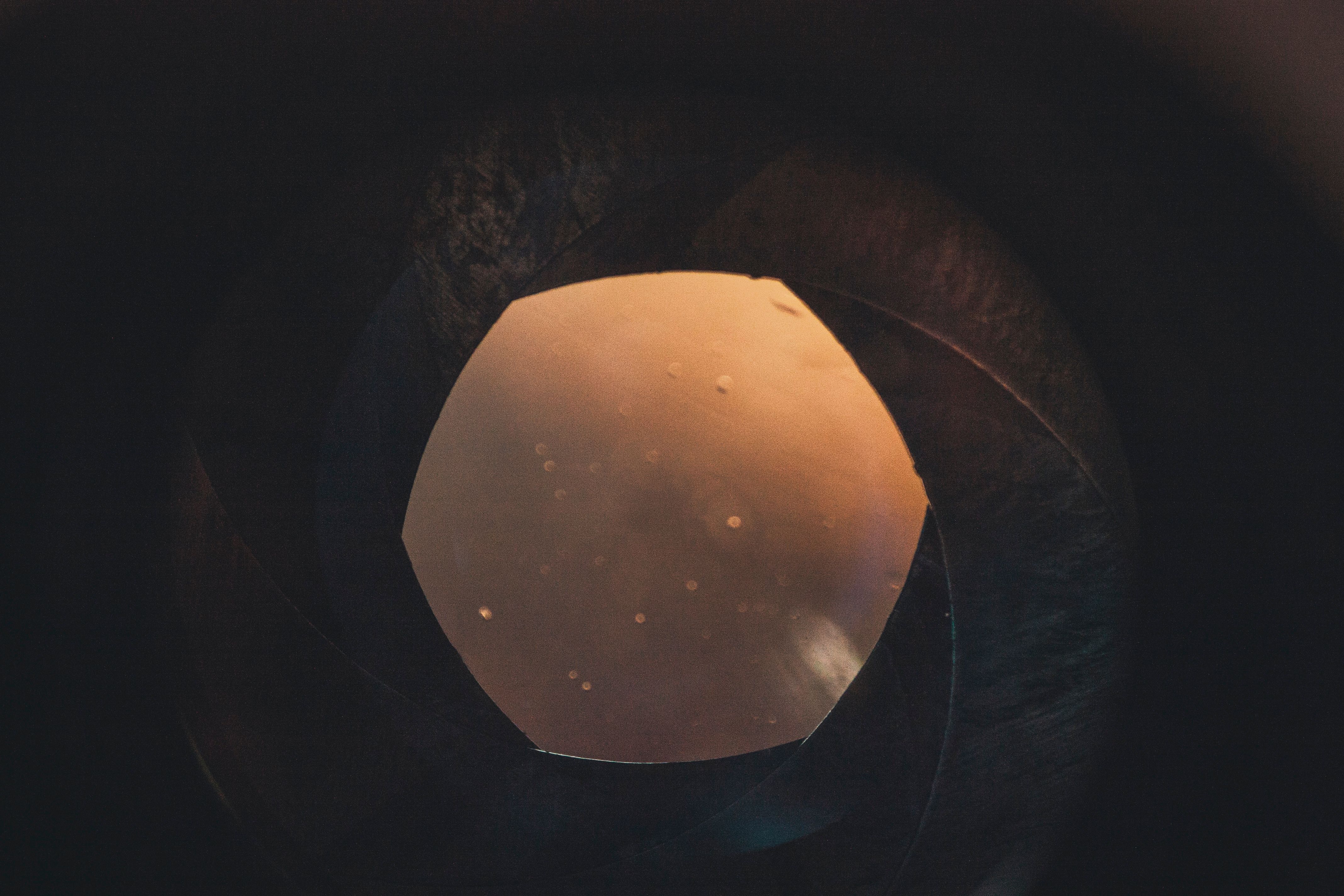 An artistic look inside a camera lens with warm glow and circular bokeh.