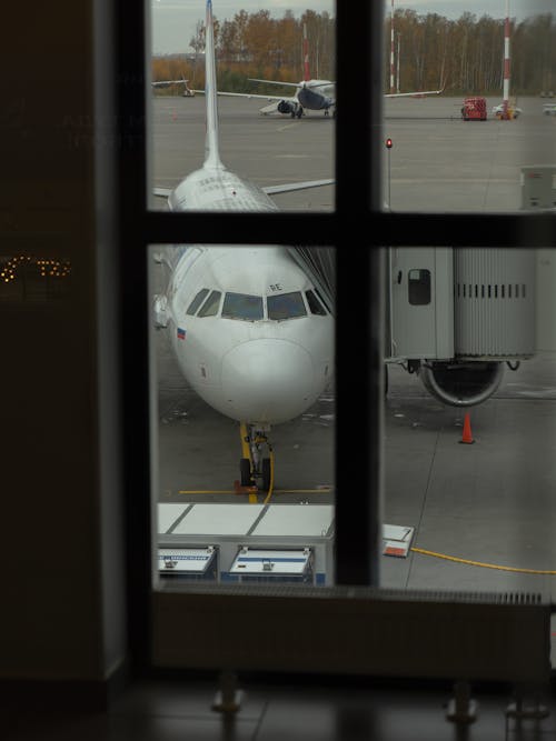 Free View of Airplane Parked at the Airport from a Window Stock Photo