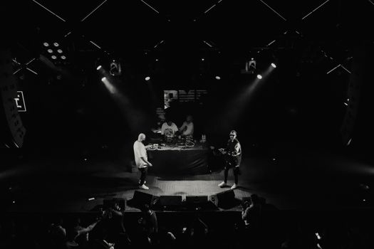 Black and white aerial shot of musicians performing live on stage.