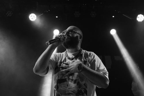 Free Black and white image of a bearded musician singing live with dynamic lighting. Stock Photo