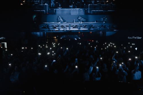 Free A lively concert scene with a crowd holding up smart phones and lights, creating an electrifying atmosphere. Stock Photo