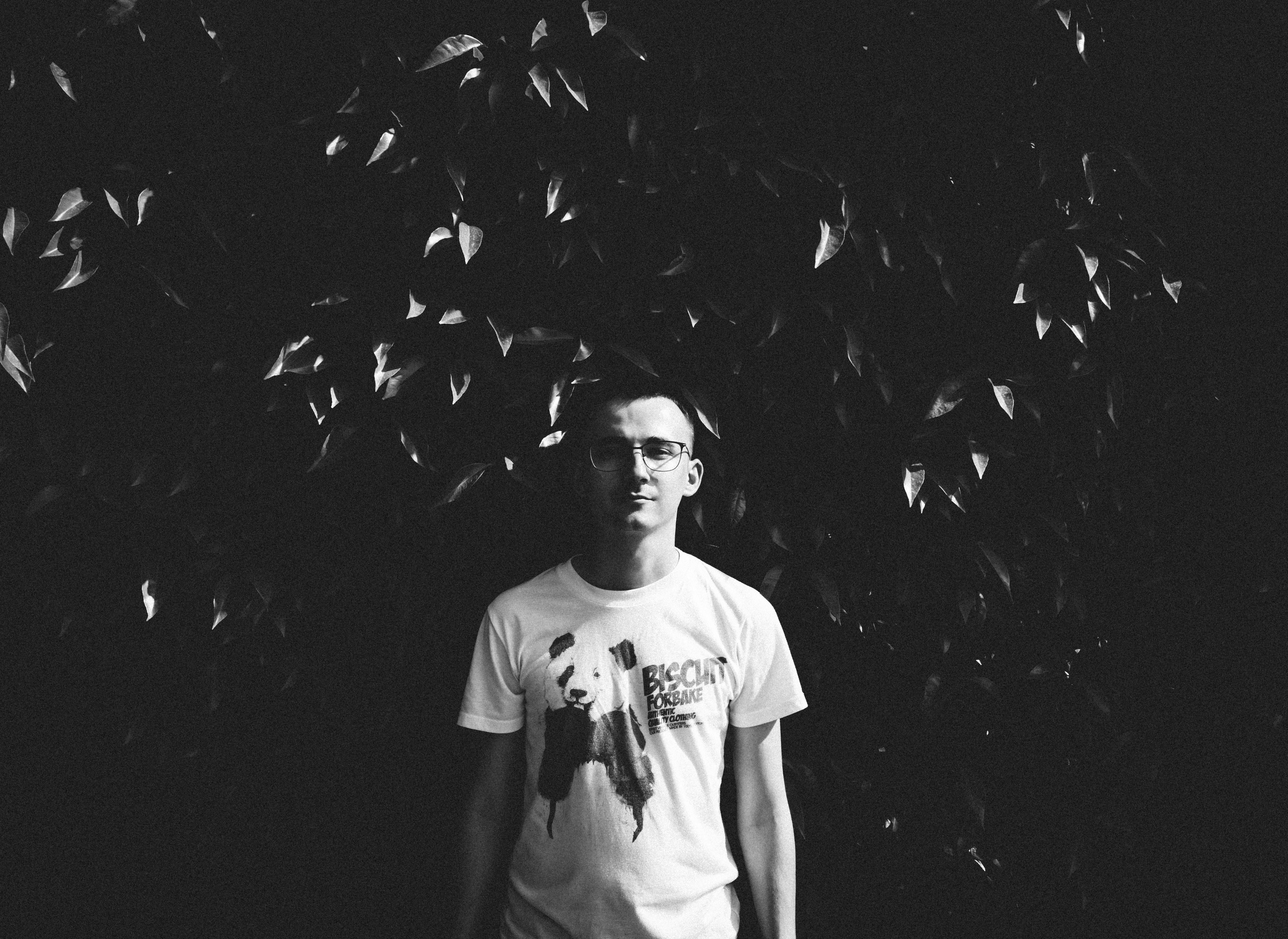a grayscale photo of a man in white shirt