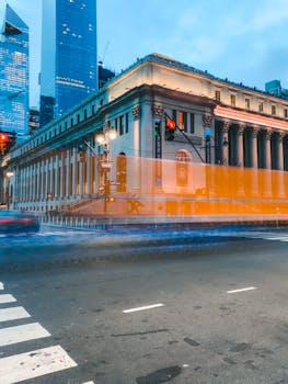 Vibrant city scene of New York's James Farley Post Office with motion blur traffic at dusk.