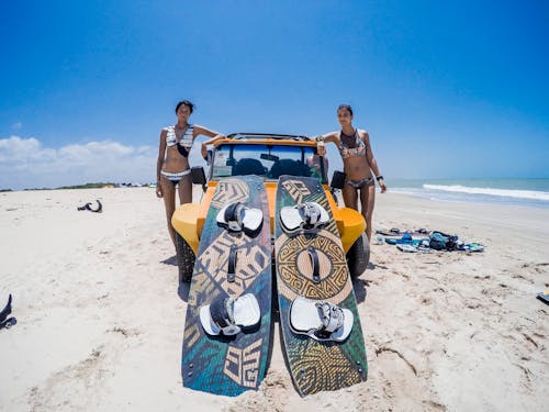 Free Women in Bikini Standing Near the Car on the Beach Stock Photo