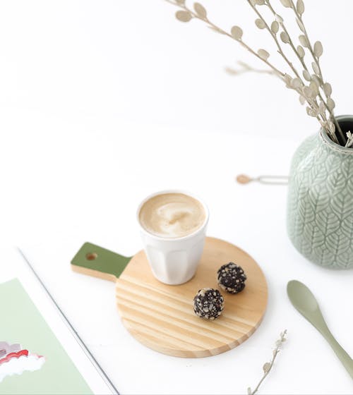 Free Elegant setup with coffee and chocolate truffles on a wooden coaster, perfect for cozy moments. Stock Photo
