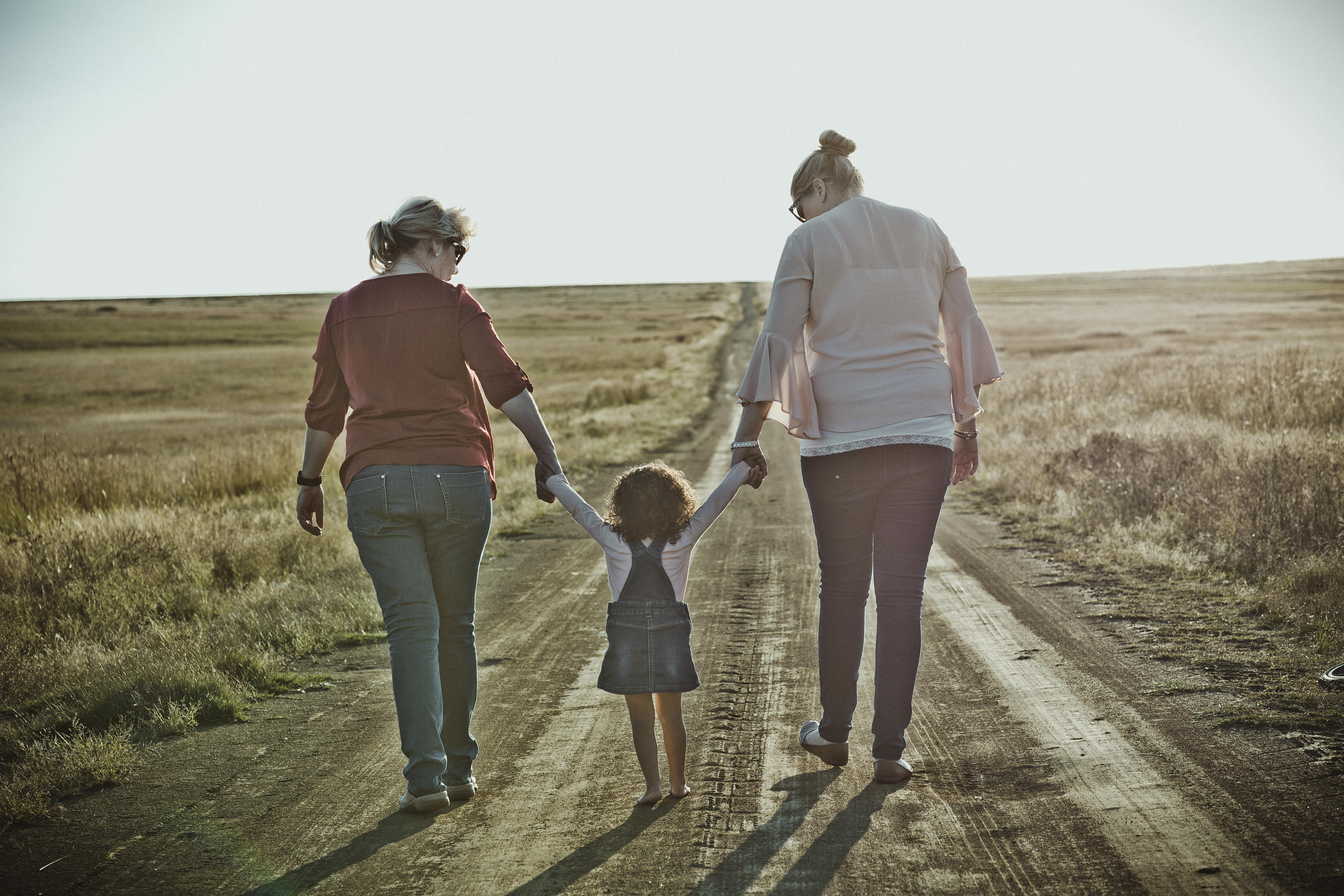 photography of women walking on dirt road