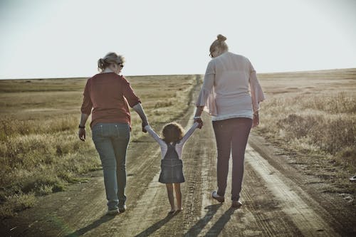 未舗装の道路を歩く女性の写真