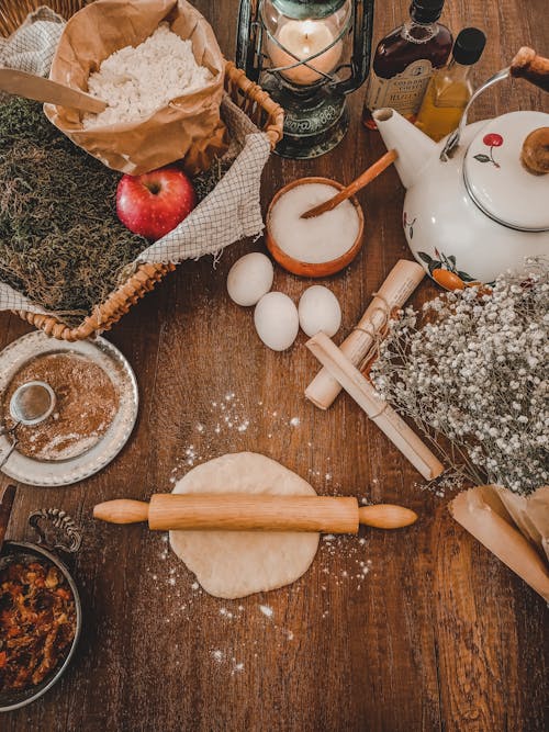 Dough with Rolling Pin on Wooden Table with Apple Pie Ingredients