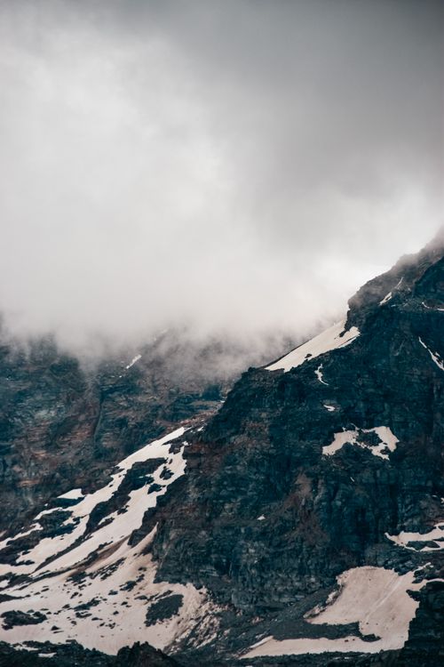 Free Captivating mountain landscape with clouds and snow showcasing a moody winter atmosphere. Stock Photo