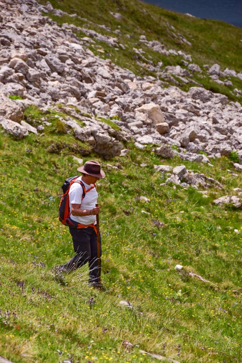 Man Wearing Cowboy Hat with Backpack Going Down a Mountain 