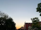 A Concrete Building Near the Green Trees Under the Blue Sky