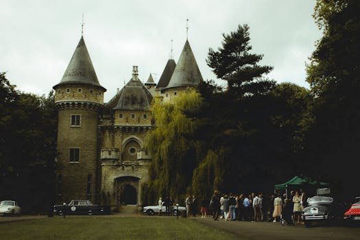 阴天，一座美丽的石堡外聚集着古董汽车
