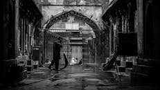 一名孤独的男子走在历史悠久的封闭城区潮湿的街道上