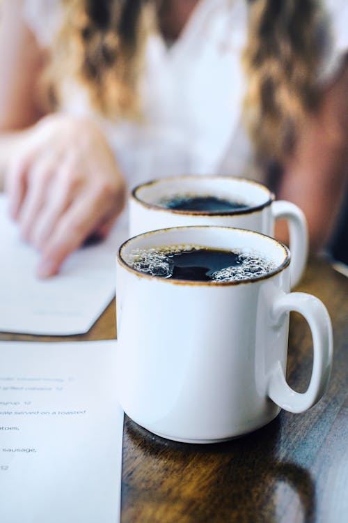 Close-Up Photo of Two White Mugs with Black Coffee