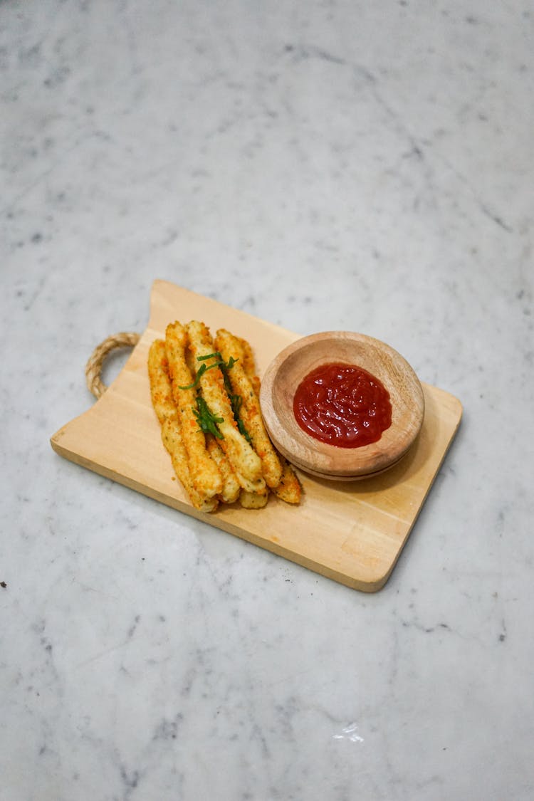 Fried Cheese Stick On A Wooden Plate With Dipping On The Side