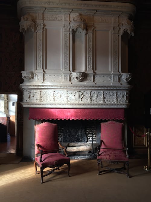 Antique Red Armchairs Near a Fireplace