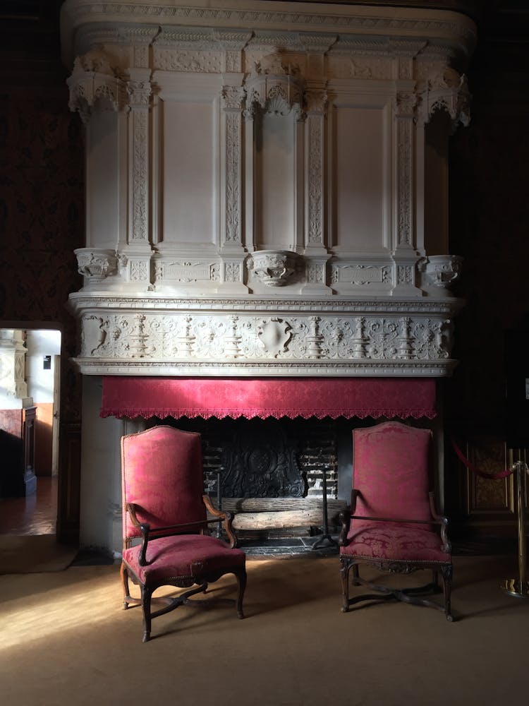 Antique Red Armchairs Near A Fireplace