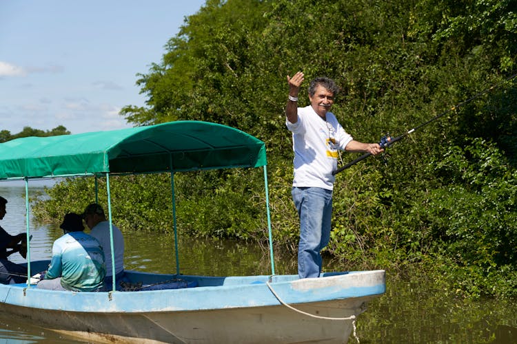 Photo Of A Man In A White Shirt Holding A Fishing Rod