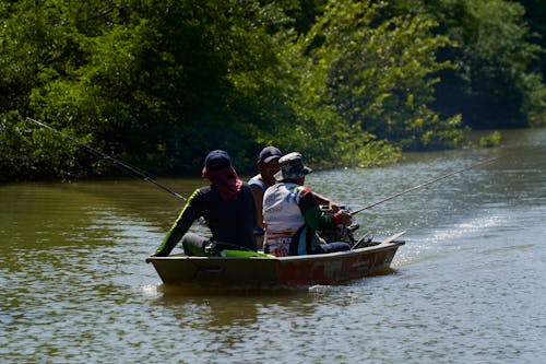 Three Men Riding on a Boat and Fishing