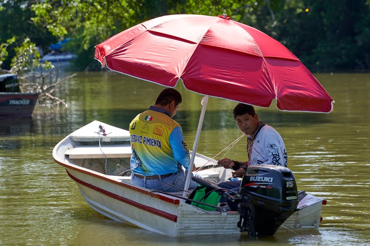 Two Men Fishing On A Motorboat