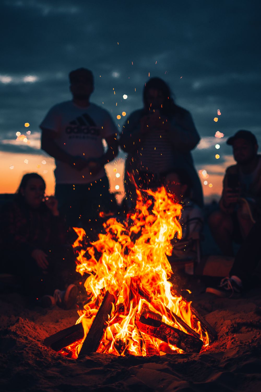 Friends around a bonfire at twilight