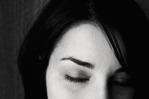 Monochrome Photo of a Woman Closing Her Eyes