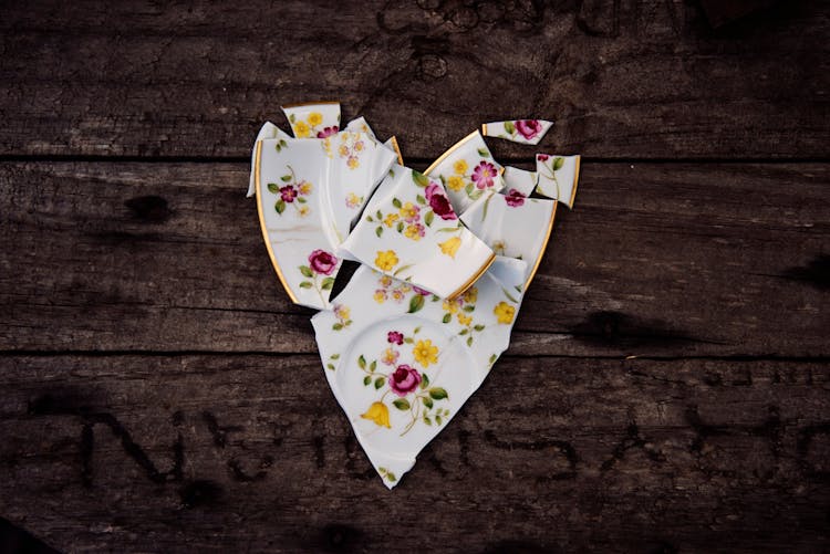 Broken Ceramic Plate On Wooden Table