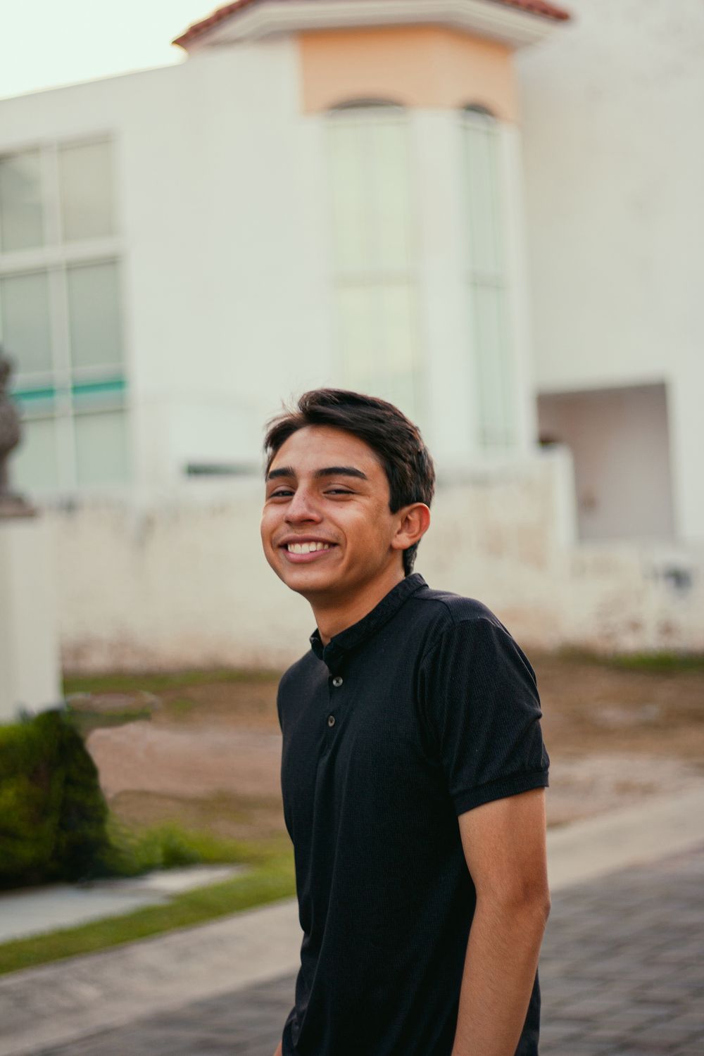 A Smiling Young Man Wearing a Black Polo Shirt · Free Stock Photo